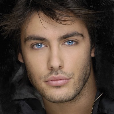 a brunette man with blue eyes