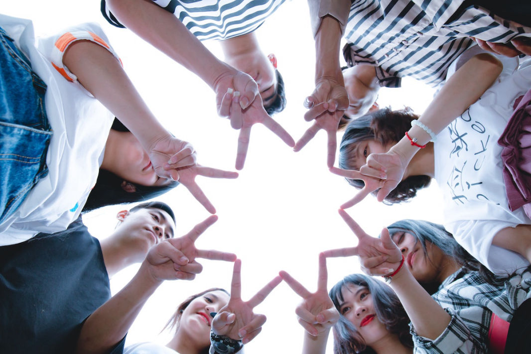 people forming a star with their fingers